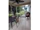 Enclosed patio with a table and chairs, tile flooring, and an exterior access door at 9215 Se 177Th Simons Ln, The Villages, FL 32162