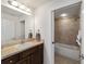 Clean bathroom with tub, shower, and vanity with dark wood cabinets at 5072 Neptune Cir, Oxford, FL 34484