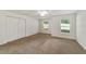 Bright bedroom with carpet flooring, double door closet, and two windows at 5072 Neptune Cir, Oxford, FL 34484