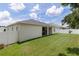 Spacious, fenced backyard featuring lush grass, a covered patio, and a well-maintained lawn at 6834 Mossy Oak Ln, Lakeland, FL 33810