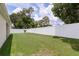 Private backyard features a white fence surrounding a large, manicured lawn and mature trees at 6834 Mossy Oak Ln, Lakeland, FL 33810