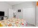 Bedroom featuring a television set, a double door closet, and a bed with a red floral pattern at 6834 Mossy Oak Ln, Lakeland, FL 33810