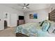 Bright bedroom featuring a ceiling fan, an art piece and a large bed with patterned bedspread at 6834 Mossy Oak Ln, Lakeland, FL 33810