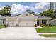 Charming single-story home featuring a three-car garage, well-manicured lawn, and beautiful landscaping at 6834 Mossy Oak Ln, Lakeland, FL 33810