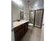 Bathroom featuring a single sink vanity and walk-in shower with gray tiled walls at 2252 Juniper Berry Dr, Minneola, FL 34715
