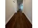 Hallway featuring wood-look floors and white trim with doors along the hall at 2252 Juniper Berry Dr, Minneola, FL 34715