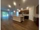 Open-concept kitchen with dark wood cabinets, stainless appliances and large island at 2252 Juniper Berry Dr, Minneola, FL 34715