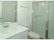 Modern bathroom featuring glass enclosed shower, white fixtures and countertop with a mirrored wall at 2311 Juniper Berry Dr, Minneola, FL 34715