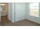 Bedroom featuring carpeted floors, a window with natural light, and an adjacent bathroom at 2311 Juniper Berry Dr, Minneola, FL 34715