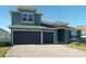 Charming two-story home featuring a two-car garage, well-manicured lawn, and brick-paved driveway at 2311 Juniper Berry Dr, Minneola, FL 34715