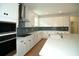 Modern kitchen featuring white cabinets, stainless steel appliances, gray backsplash, and a large island with marble countertop at 2311 Juniper Berry Dr, Minneola, FL 34715