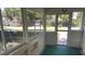 Enclosed front porch with windows that look out onto the surrounding neighborhood at 1010 S Grove St, Eustis, FL 32726