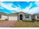 Curb appeal with gray siding, blue door, and brick driveway at 5807 Wallis Ln, Saint Cloud, FL 34771