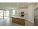 Open kitchen with white cabinets, island, and sliding glass doors at 5807 Wallis Ln, Saint Cloud, FL 34771