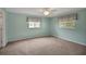 Bedroom with soft neutral carpet, ceiling fan and natural light from two bright windows at 17548 Se 96Th Ave, Summerfield, FL 34491