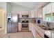 Well-equipped kitchen with stainless steel appliances, white cabinets, and modern fixtures at 17548 Se 96Th Ave, Summerfield, FL 34491
