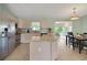 Bright kitchen with stainless steel appliances, white cabinetry, and an adjacent dining area at 17548 Se 96Th Ave, Summerfield, FL 34491