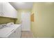 This laundry room has a washer, dryer, storage, and a door to the outside at 17548 Se 96Th Ave, Summerfield, FL 34491