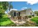 Cozy outdoor patio with brick pavers and seating area surrounded by lush green lawn at 17548 Se 96Th Ave, Summerfield, FL 34491
