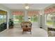 Enclosed sunroom with tile floor, multiple windows, and serene backyard view at 17548 Se 96Th Ave, Summerfield, FL 34491
