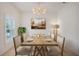 Bright dining room featuring a wooden table with seating for six under a decorative chandelier at 1103 White Water Bay Dr, Groveland, FL 34736