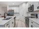 Spacious kitchen with white cabinets, stainless steel appliances, and a large island at 1103 White Water Bay Dr, Groveland, FL 34736