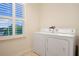 Bright laundry room featuring a washer, a dryer, and a window with shutters at 1103 White Water Bay Dr, Groveland, FL 34736