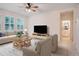 Cozy living room with neutral-toned furniture, a large window, and a view into a bathroom at 1103 White Water Bay Dr, Groveland, FL 34736