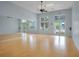 Spacious recreation room with wood floors, large windows, mirrors, and an exit door at 1103 White Water Bay Dr, Groveland, FL 34736