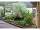 Backyard area with a tranquil pond surrounded by lush greenery and a screened enclosure at 14700 Se 94Th Ave, Summerfield, FL 34491