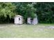 Two storage sheds in backyard, offering functionality and additional storage space with mature trees at 14700 Se 94Th Ave, Summerfield, FL 34491