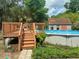 Above ground pool with wooden deck access, and storage shed surrounded by greenery at 14700 Se 94Th Ave, Summerfield, FL 34491