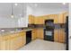 Traditional kitchen features wood cabinets, tile backsplash, and black appliances at 14853 Sw 26Th Ln, Ocala, FL 34481