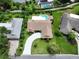 An aerial view of a home with a long driveway and backyard pool surrounded by lush greenery at 213 Stevenage Dr, Longwood, FL 32779