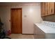 Bright laundry area features a washer, dryer, storage cabinets, and convenient access to an exterior door at 213 Stevenage Dr, Longwood, FL 32779