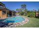 Backyard pool with stone decking, surrounded by lush landscaping and a well-manicured lawn at 213 Stevenage Dr, Longwood, FL 32779