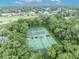 Aerial view of the community tennis courts nestled among trees shows an active lifestyle at 213 Stevenage Dr, Longwood, FL 32779