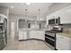 Modern kitchen featuring white cabinetry, stainless steel appliances, and granite countertops at 17000 Se 76Th Creekside Cir, The Villages, FL 32162