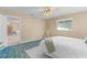 Bright bedroom with a ceiling fan, cozy decor, and ample natural light from the window at 17574 Se 106Th Ave, Summerfield, FL 34491