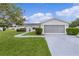 Charming single-story home featuring a well-maintained lawn and an attached two-car garage with screened doors at 17574 Se 106Th Ave, Summerfield, FL 34491