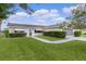 Inviting home entrance with well-manicured shrubs and stylish black and white striped awnings over the windows at 17574 Se 106Th Ave, Summerfield, FL 34491