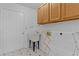 Functional laundry room featuring a utility sink, overhead cabinets, and a convenient drying rack at 17574 Se 106Th Ave, Summerfield, FL 34491