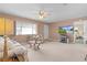 Bright living room featuring comfortable seating, a ceiling fan, and a large window at 17574 Se 106Th Ave, Summerfield, FL 34491