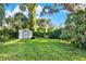 Spacious, sunny backyard featuring an old storage shed that adds character to this property at 20621 Se Highway 42, Umatilla, FL 32784