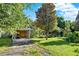 View of the front yard, carport, and facade of the property in a green setting at 20621 Se Highway 42, Umatilla, FL 32784