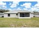 Exterior back of home featuring the screened porch and a well-maintained lawn at 8878 Se 158Th St, Summerfield, FL 34491