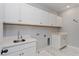 Laundry room with white cabinets, countertop, and stainless steel sink at 10092 Ballast Dr, Orlando, FL 32827