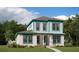 Charming two-story home featuring white stucco, teal trim, manicured lawn, and a welcoming entrance at 10430 Pearson Ave, Orlando, FL 32827