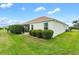 View of the house's side, showing a screened patio and hedges at 3732 Barrel Loop, The Villages, FL 32163