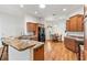 Kitchen with an island, wood cabinets, and granite countertops at 3732 Barrel Loop, The Villages, FL 32163